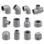 An assortment of grey PVC pipe fittings: elbows, tees, a cross, sockets, reducers, caps and threaded adaptors.