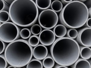 The open ends of grey PVC pipes of many diameters stacked together.